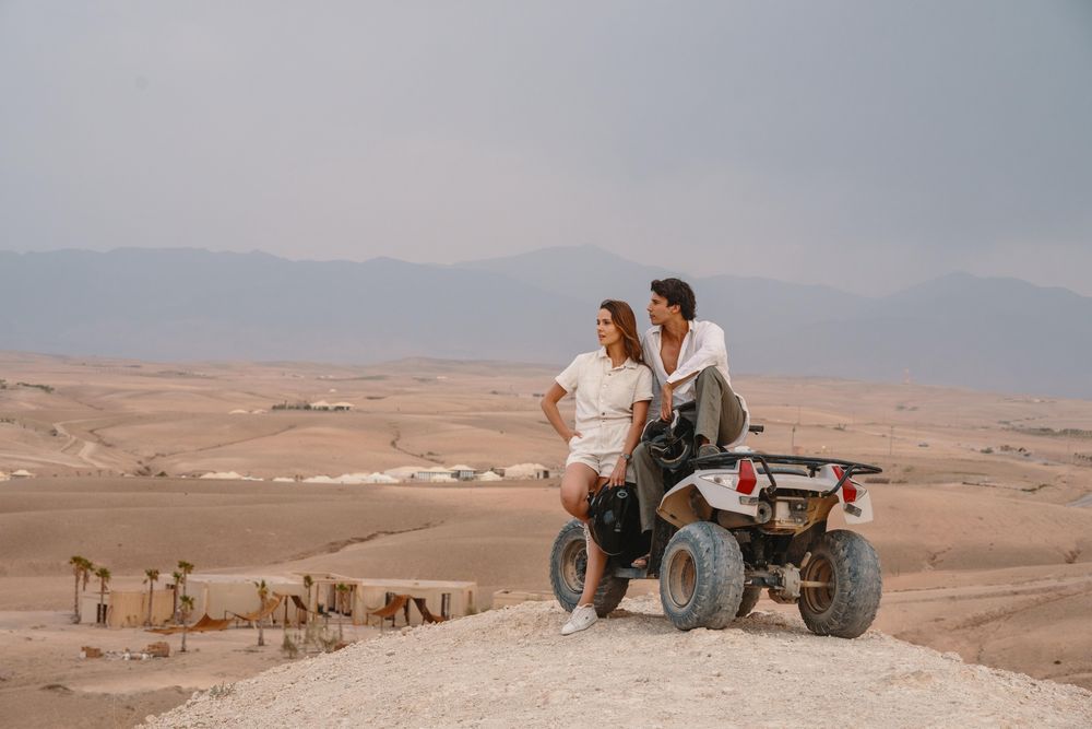 Couple on a quad bike on a hilltop in the Agafay desert